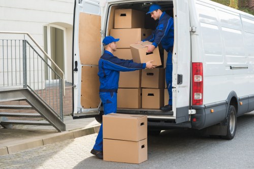 Professional movers handling stairs and furniture during a Holland Park flat removal